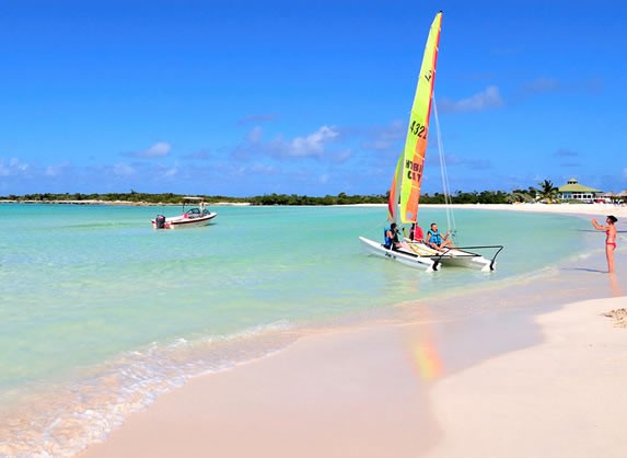 catamarán zarpando en la playa bajo el cielo azul