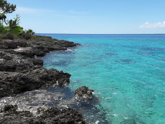playa con orilla rocosa y aguas azules