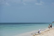 tourists walking on the beach on a sunny day