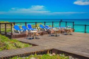 sun loungers on wooden pier in front of the beach