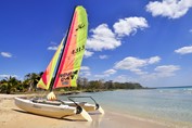 playa del hotel con barco de vela en la orilla