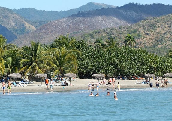 playa con montañas y vegetación al fondo