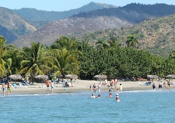 beach with mountains and vegetation in the back