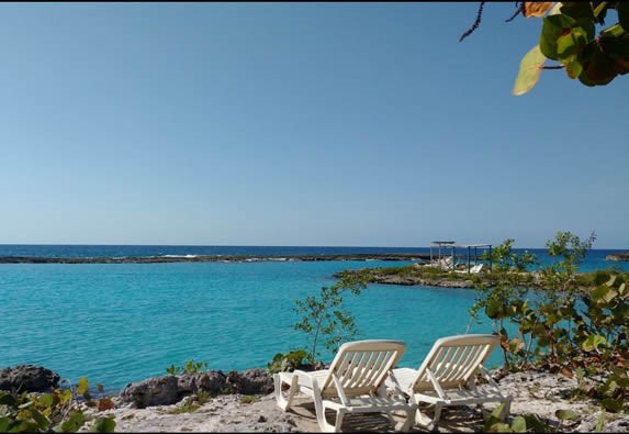 vista del mar azul  y tumbonas encima de las rocas