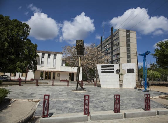 plaza con monumento de mármol y árboles