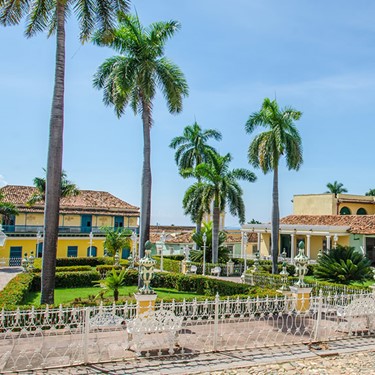 square surrounded by colonial buildings and palms