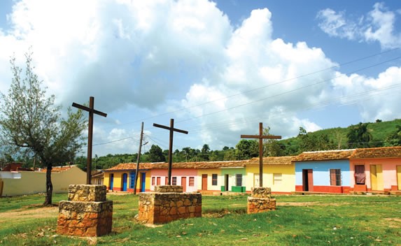 monument of three wooden crosses on the grass.