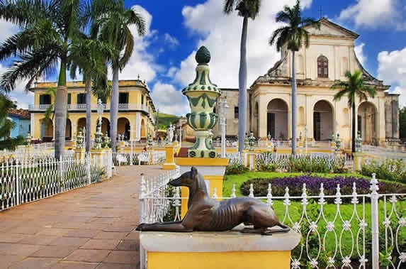 square surrounded by colonial buildings and palms