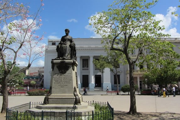 pequeña plaza con un monumento rodeada de árboles
