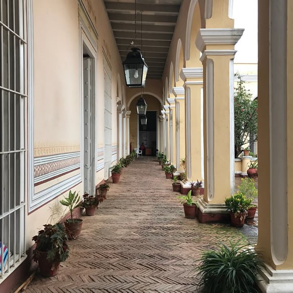 Colonial portal with plants and old street lamps.