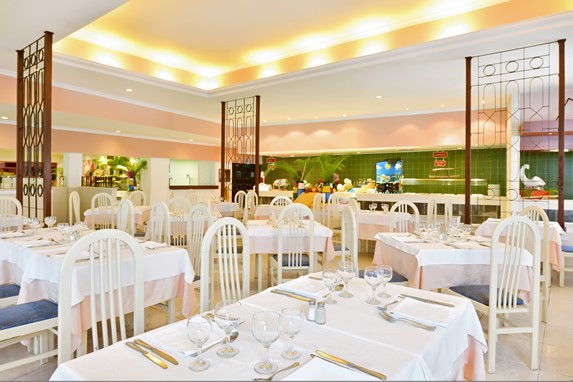 restaurante con mobiliario blanco y mantelería