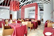 restaurant with wicker furniture and red tableclot