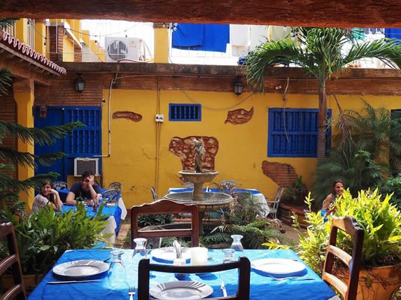 furniture in a courtyard surrounded by greenery.