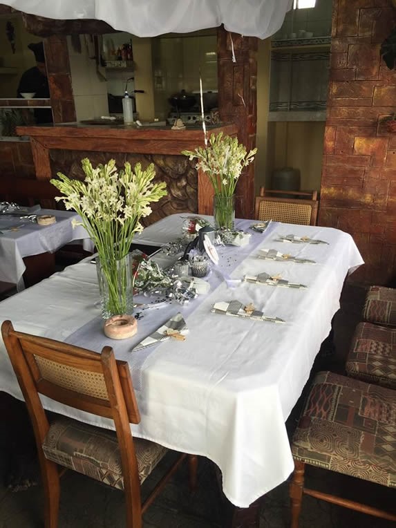 mesa de madera con mantelería y flores decorativas