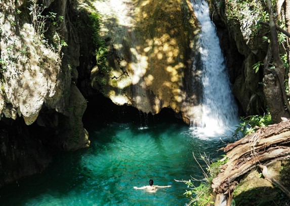 turista nadando en cascadas de aguas cristalinas 