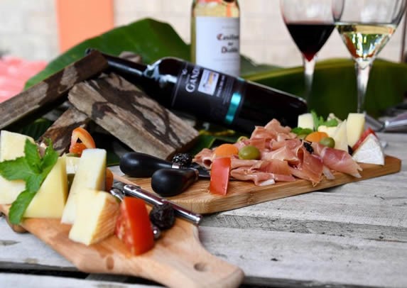 mesa servida con tabla de quesos y vino 