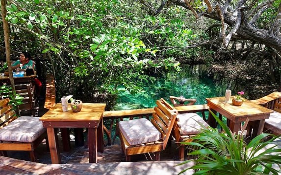 Tables surrounding the cenote in the restaurant