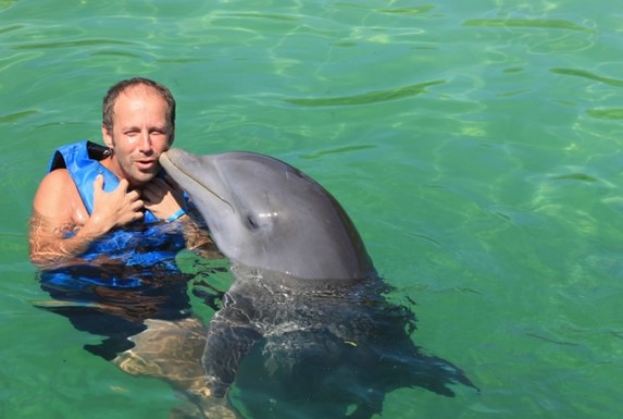 tourist in the pond swimming with gray dolphin