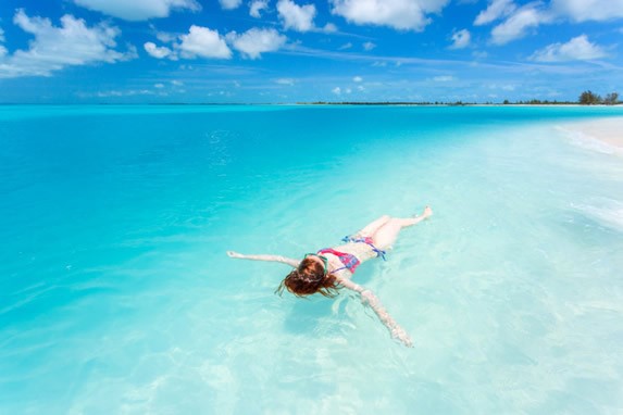 turista flotando en las aguas azules de la playa