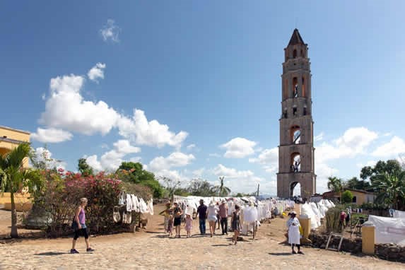 turistas comprando artesanias frente a una torre 