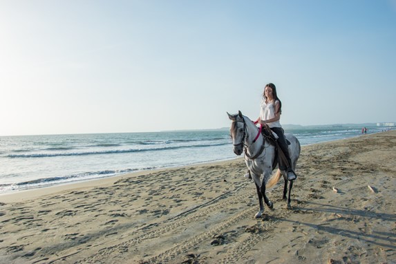 turista cabalgando por la playa