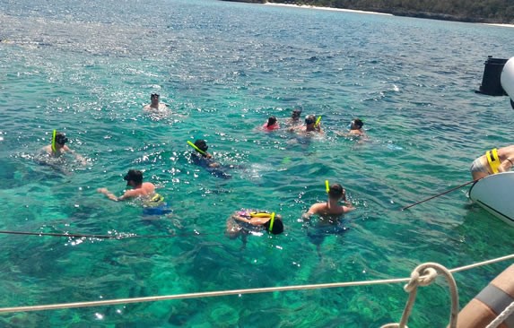 tourists snorkeling next to a boat