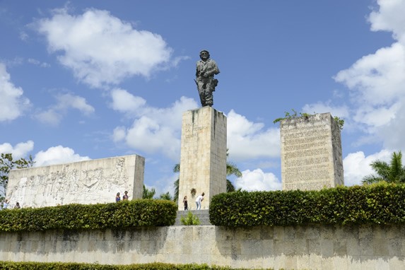 monumento de piedra y bronce rodeado de plantas