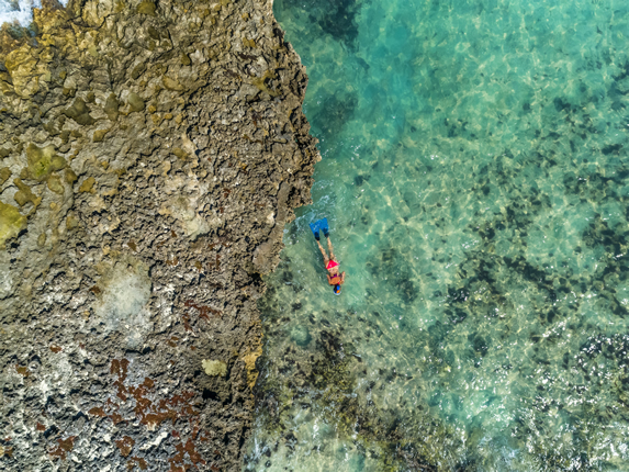 vista aérea del mar con turista haciendo snorkel