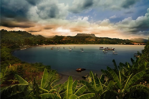 lagoon with small boats and mountain behind